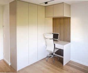 Büro in weiß mit Holzpaneelen und kleiner Sitzgelegenheit