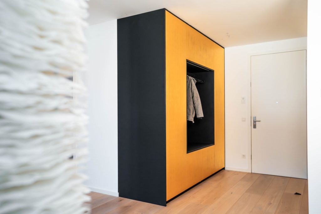 Garderobenschrank mit Sitznische in schwarz matt mit goldenen Fronten