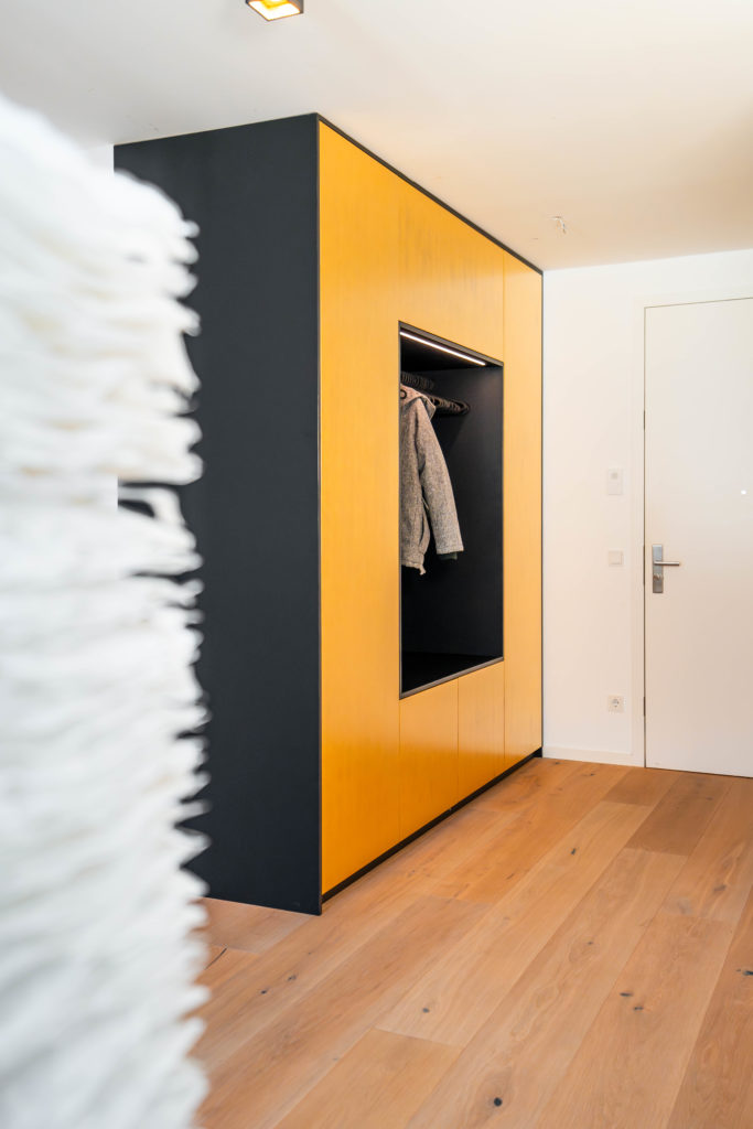 Maßgefertigter Garderobenschrank mit offener Nische in Gold und Anthrazit im modernen Flur