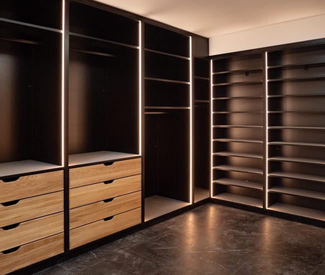 Offenes Ankleidezimmer schwarz mit Holzschubladen