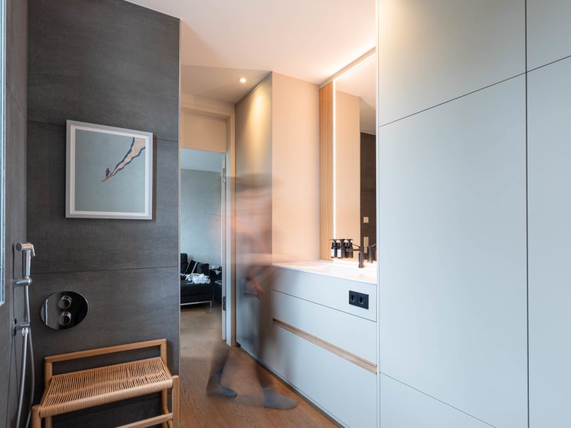 Modernes Badezimmer mit maßgefertigtem Einbauschrank und Waschplatz, Person in Bewegung