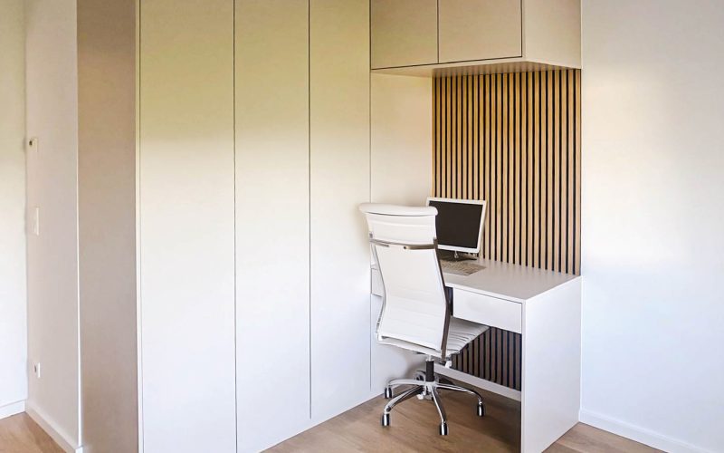 Büro in weiß mit Holzpaneelen und kleiner Sitzgelegenheit