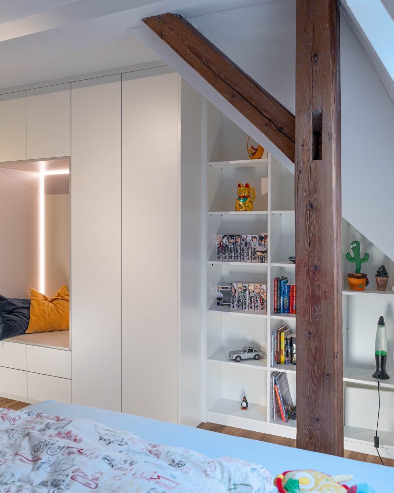 Dachschrägenschrank matt weiss Inlay hellgrau hinter Holzpfosten