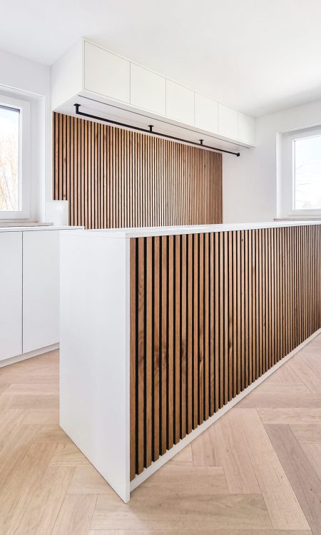 Ankleidezimmer in weiß mit Holzpaneel und schwarzer Kleiderstange