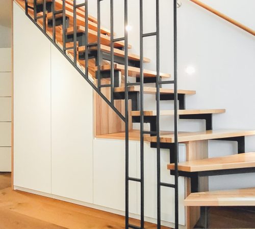 Minimalistischer Treppenschrank unter einer Holztreppe