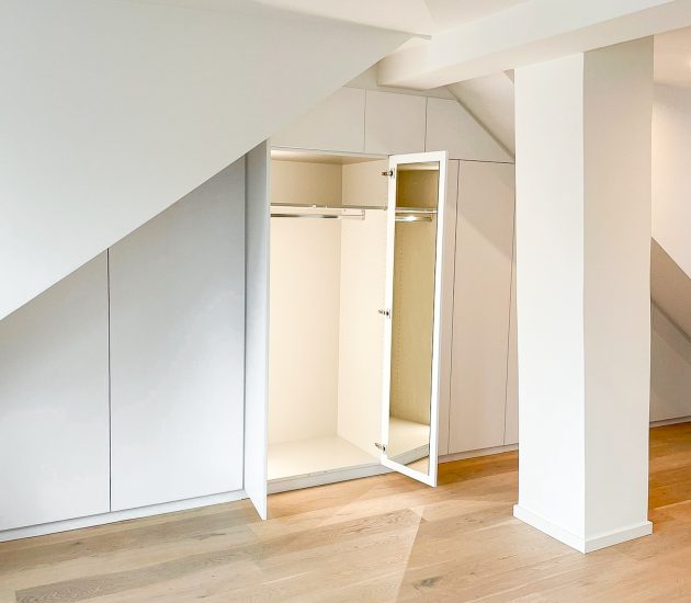 Einbauschrank mit Dachschräge in weiß mit geöffneten Türen