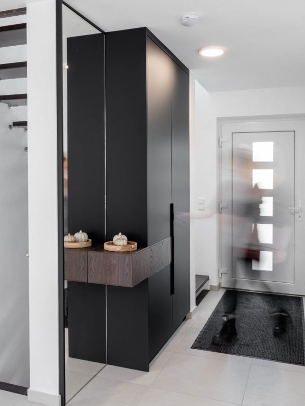 Moderner Flur mit maßgefertigter Garderobe und Spiegelfront, Person in Bewegung