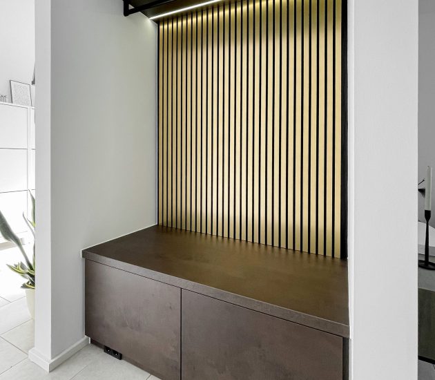 Garderobe in einer Nische mit goldenen Akustikpaneelen
