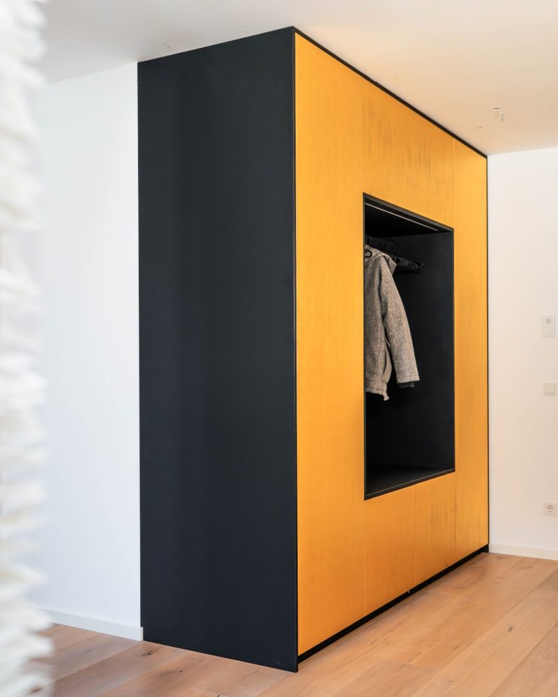 Garderobenschrank mit Sitznische in schwarz matt mit goldenen Fronten