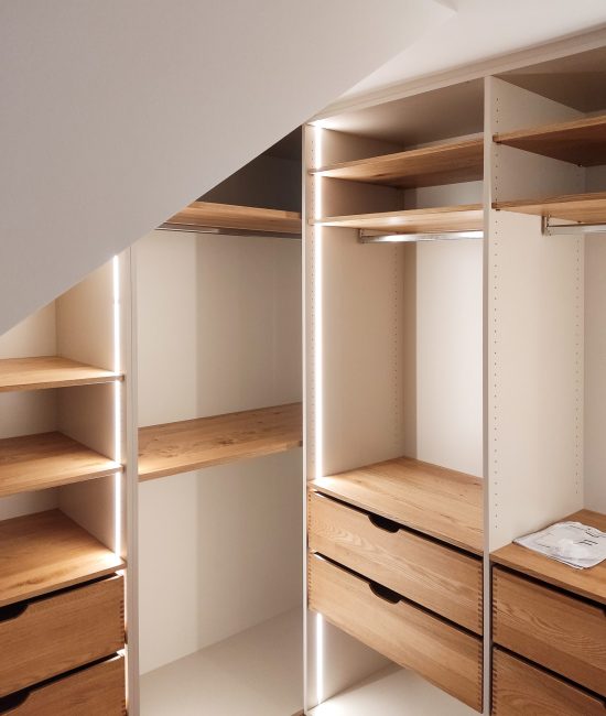 Begehbarer Kleiderschrank in einer Nische mit Schräge