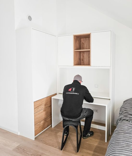 Schreibtischkombination weiß mit Eiche und Person am Schreitisch