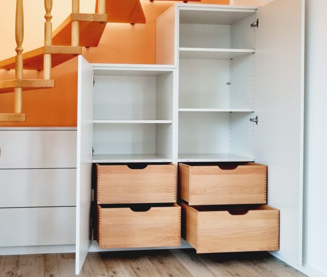 Treppenschrank geöffnet mit Holzschubladen