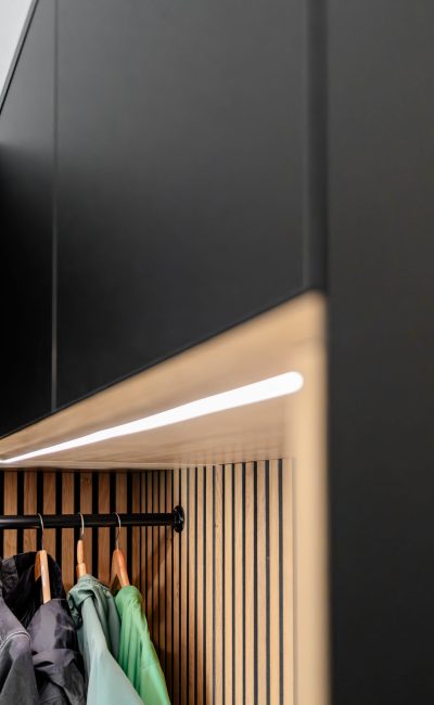 Garderobenschrank in matt-schwarz mit Eichenpaneelen und LED -  Perspektive von de Seite auf das LED Band